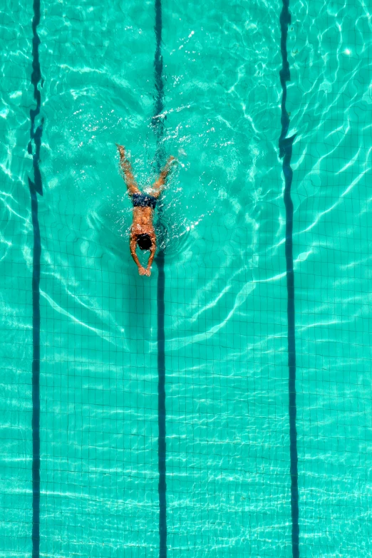 a person swimming in an empty pool with no one inside