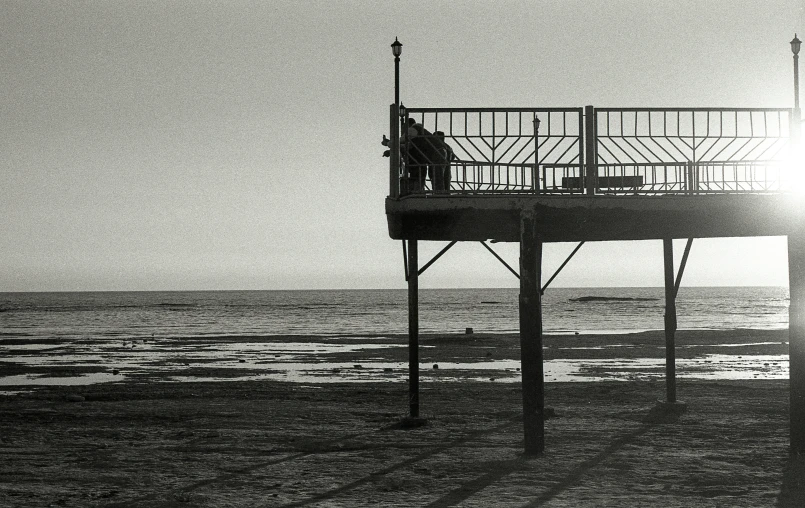 a black and white po of a boardwalk at the beach