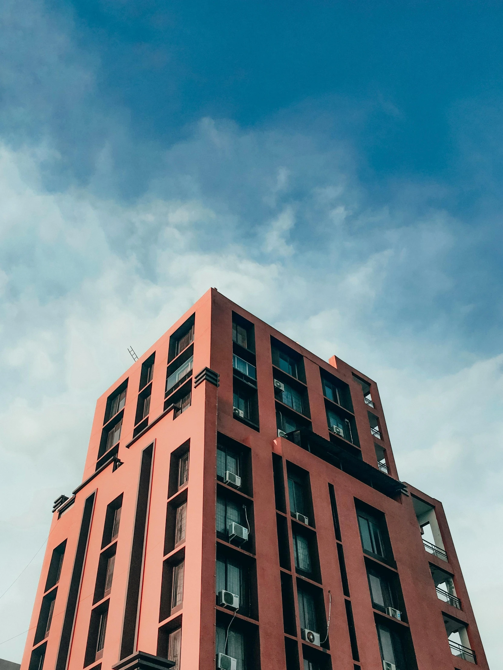 a tall building has several windows near the top