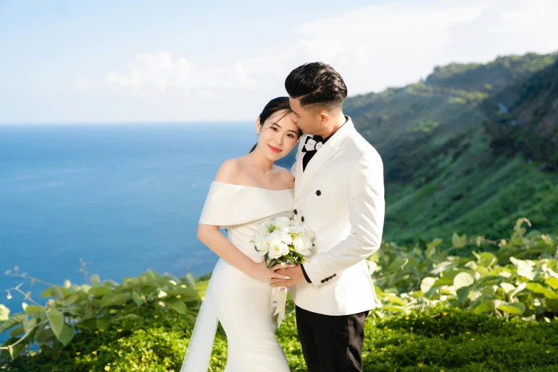 a bride and groom at their destination in front of the ocean