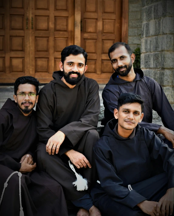 three young men in black sitting together