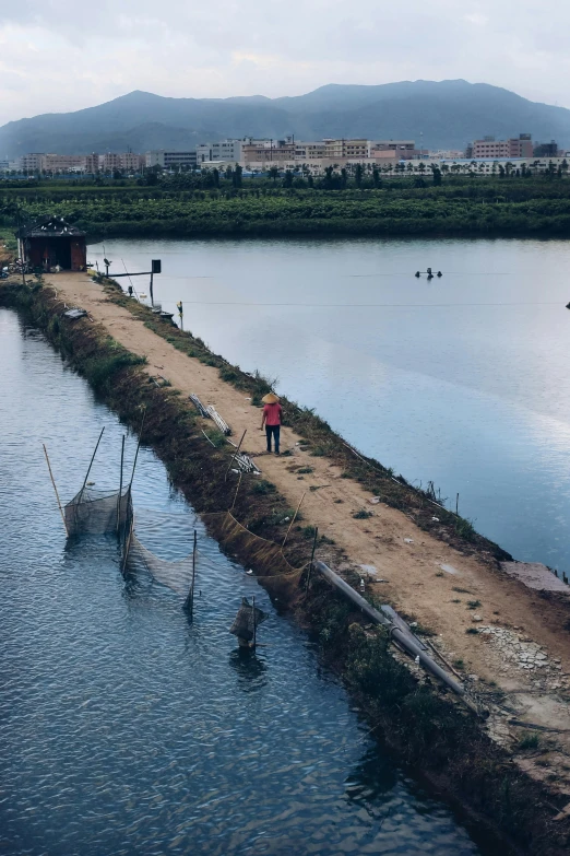 a person walking along the end of a body of water