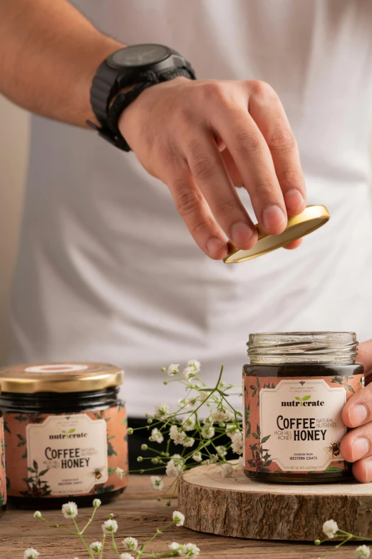 someone is holding a spoon next to some jars