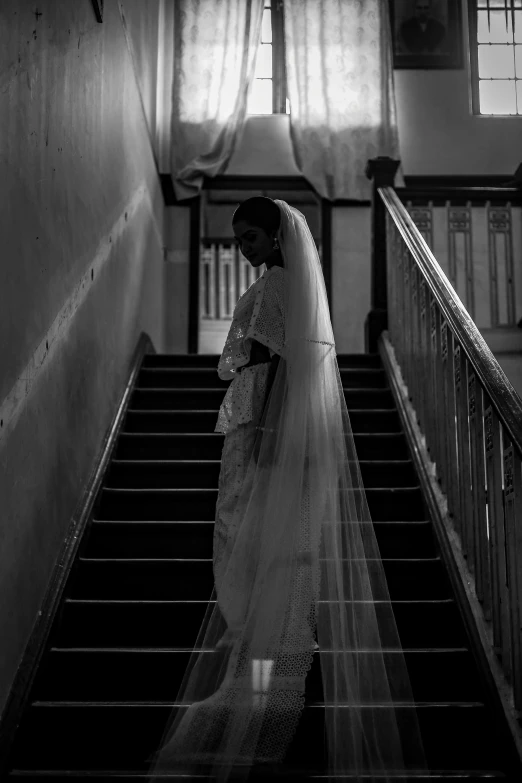 a person in a wedding dress walks down a stairway