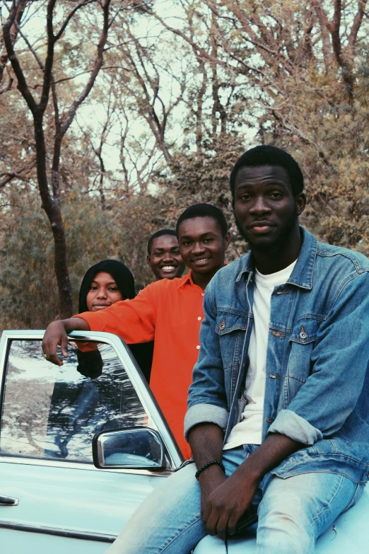 a group of men sit in a car smiling