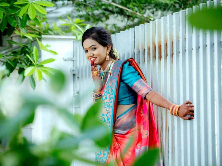 woman in blue and red saree talking on phone