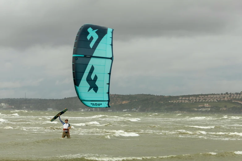 person in the water holding onto a parachute parasailing