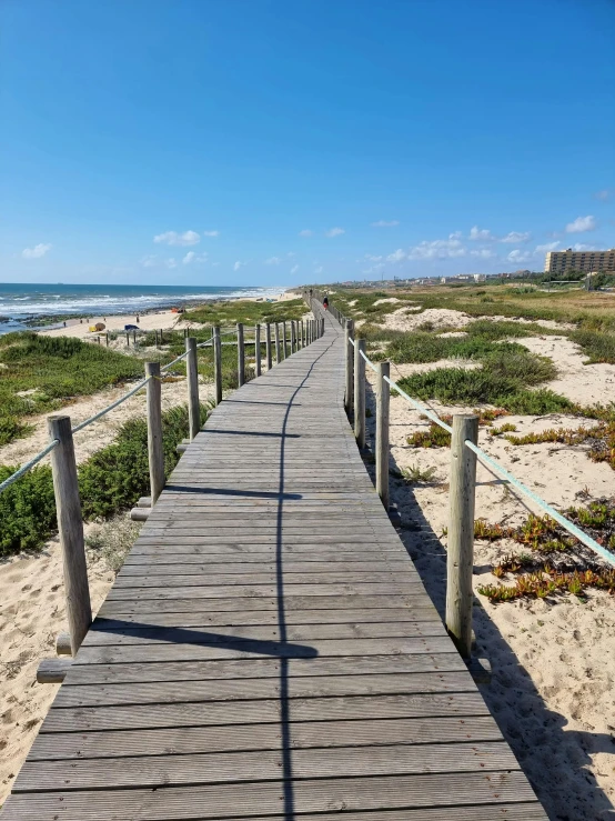 a boardwalk leading into the ocean on the beach