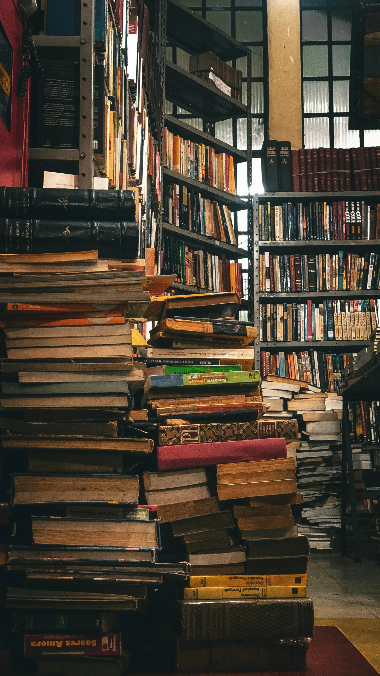 a pile of books sitting on top of a wooden shelf