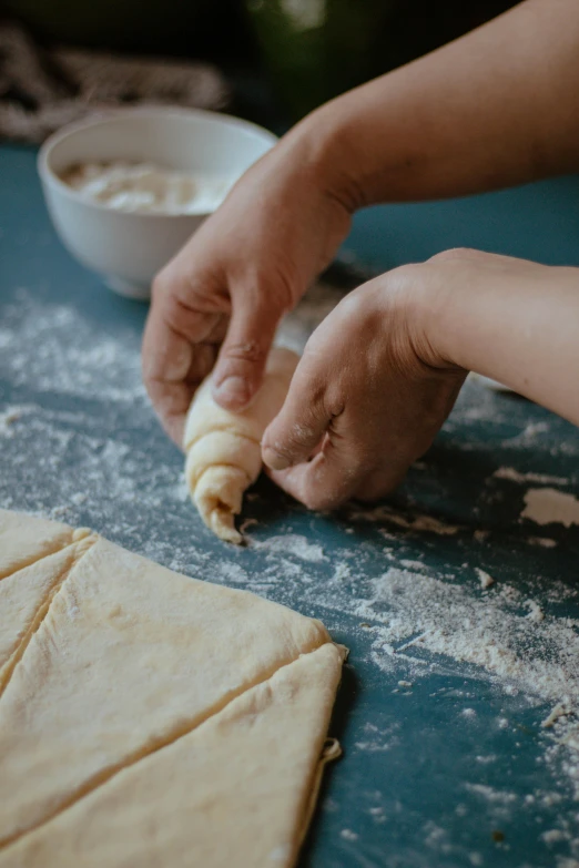 someone is rolling out dough onto a counter top