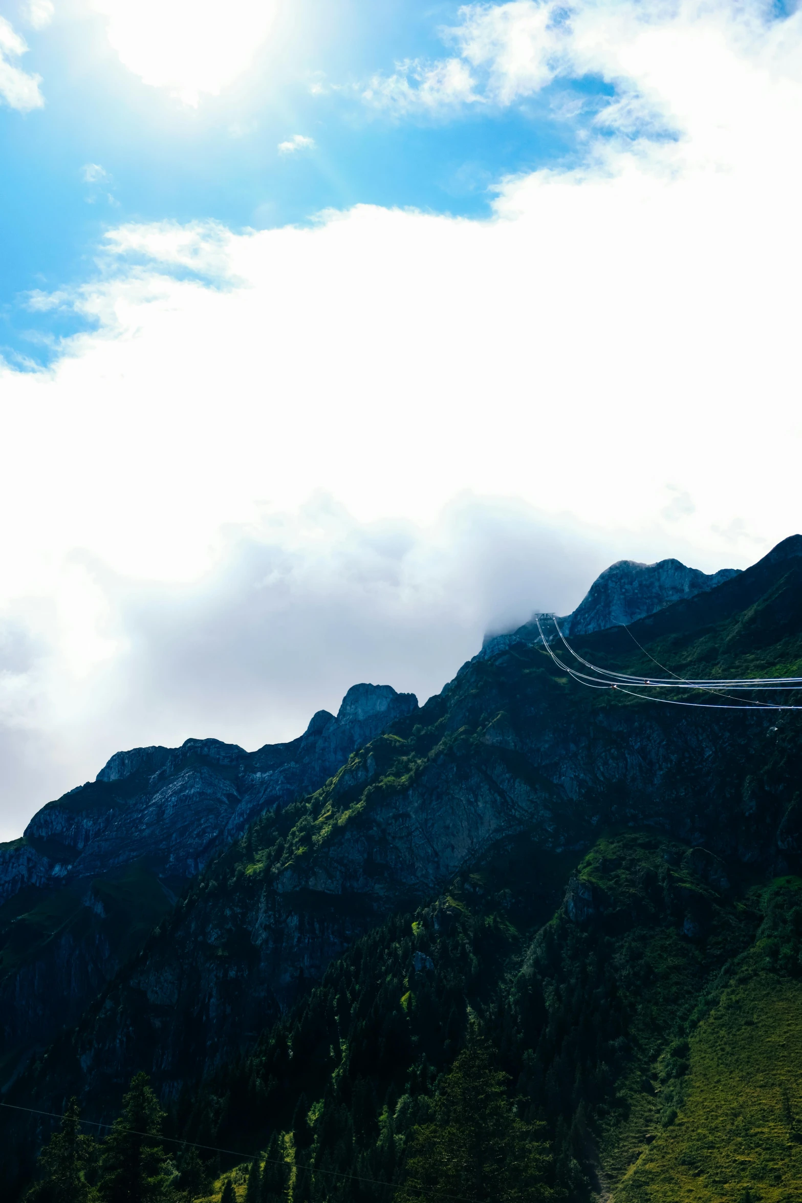 a mountain on the side has a winding road and clouds