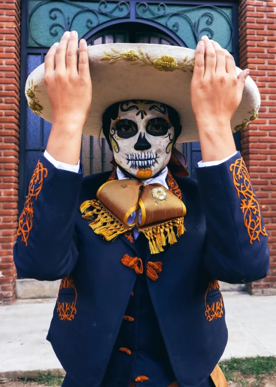 a man in an intricately decorated costume, hat, and costume is carrying a large white object