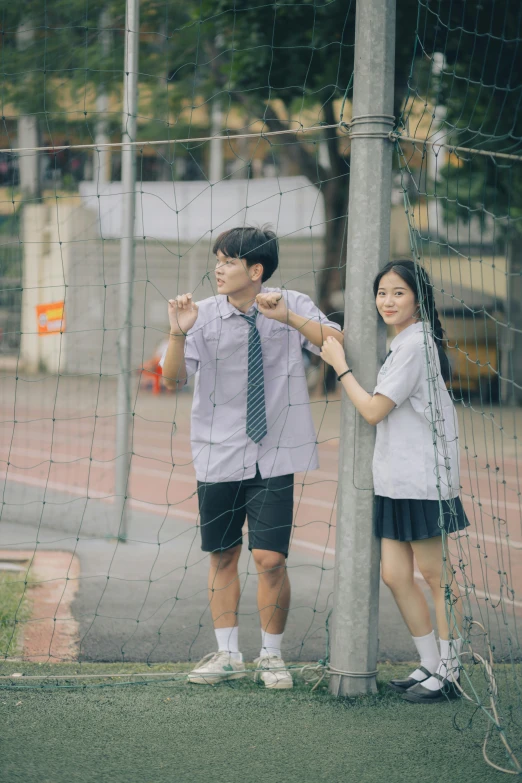 the boy is fixing the tie on the womans shirt