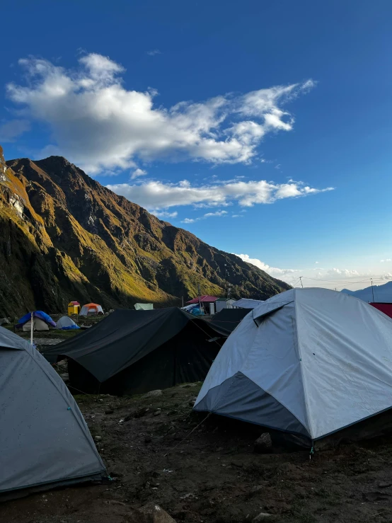 several tents are set up on the side of a mountain