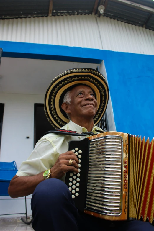 man playing an accordion near a building