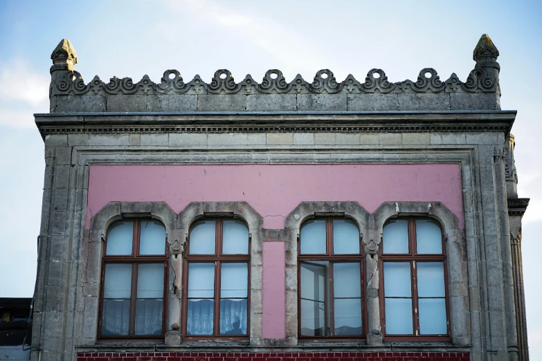 an old building that is made of concrete with red trim