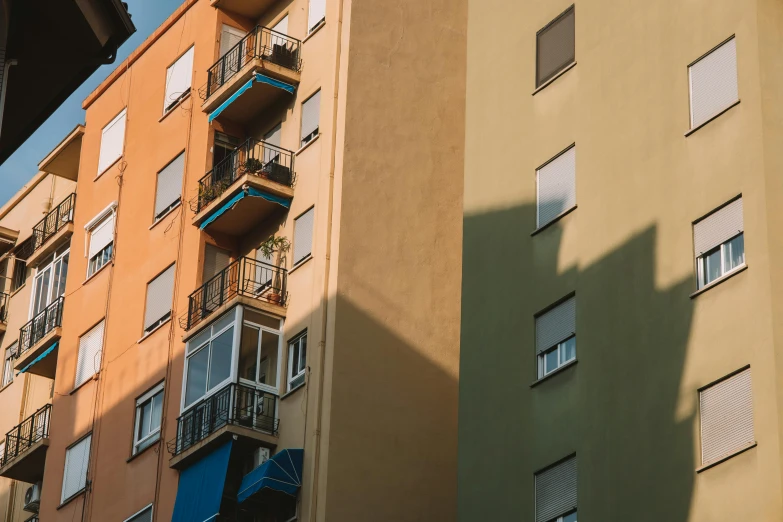 a close up of two buildings with balconies and shutters