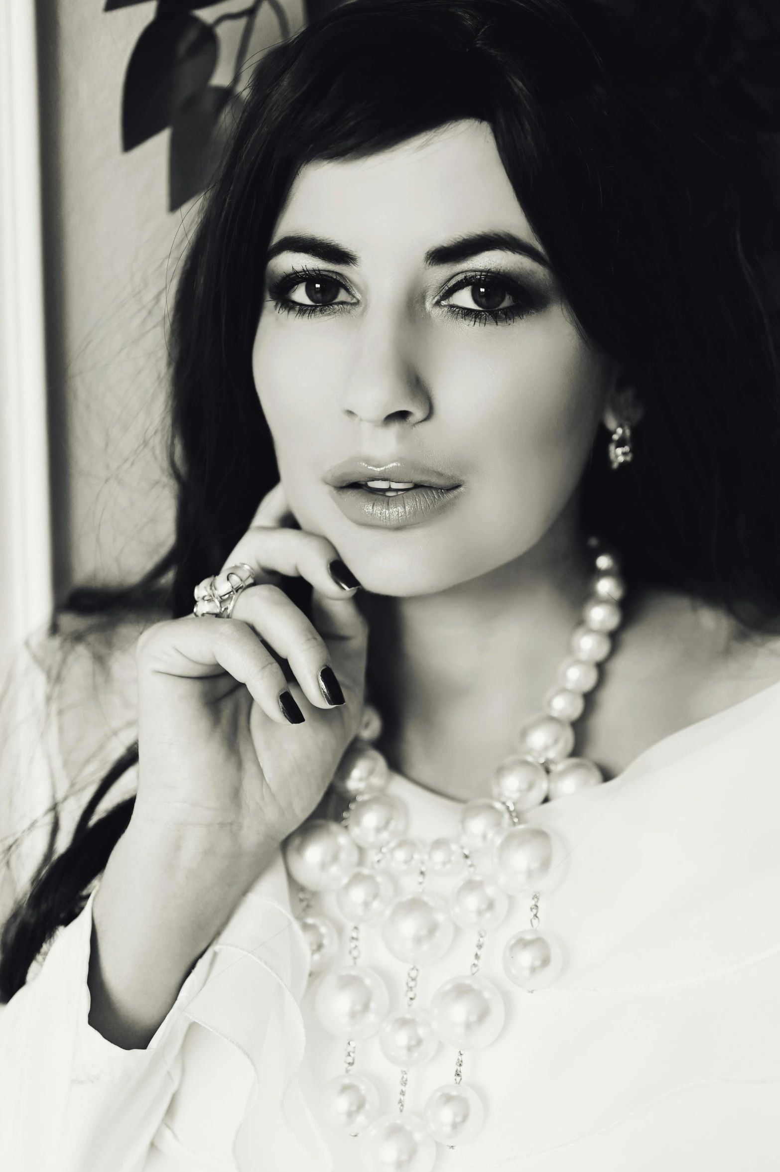 a woman with pearls is posing for a po