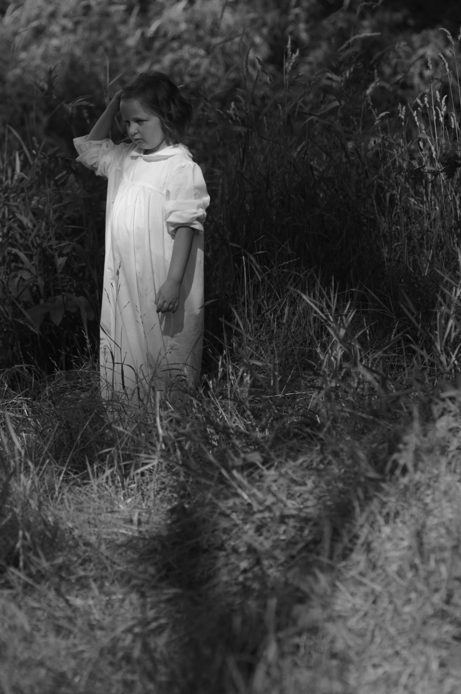 an old black and white po of a little girl wearing a dress