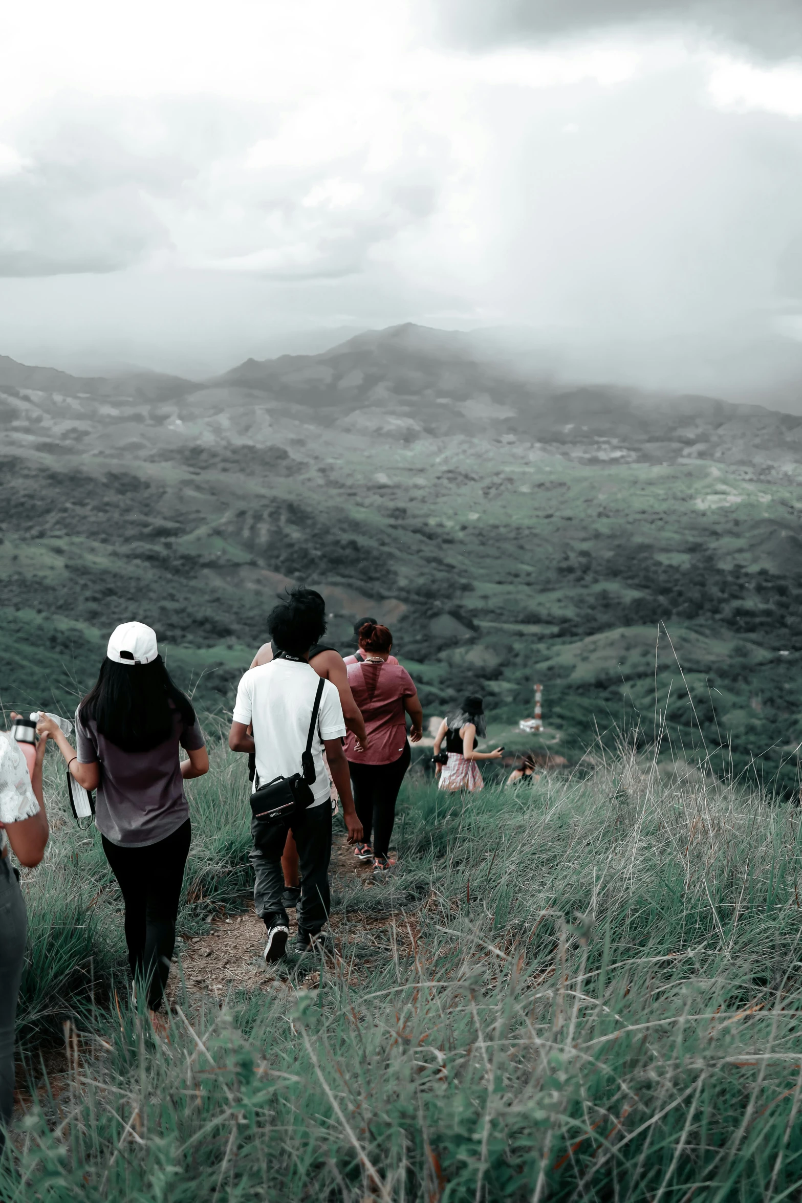 people walking uphill together on a mountain trail