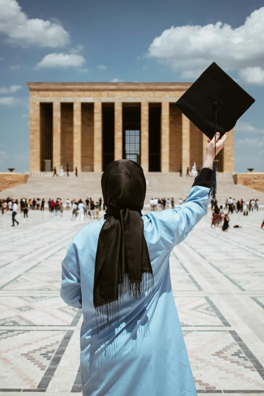 a person holding up a graduation hat in the air