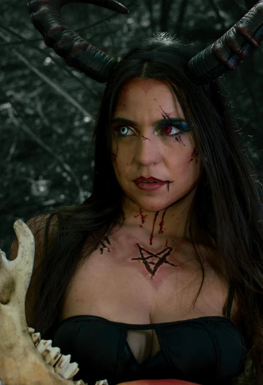 a woman dressed in devil makeup, with an elaborate horned skull