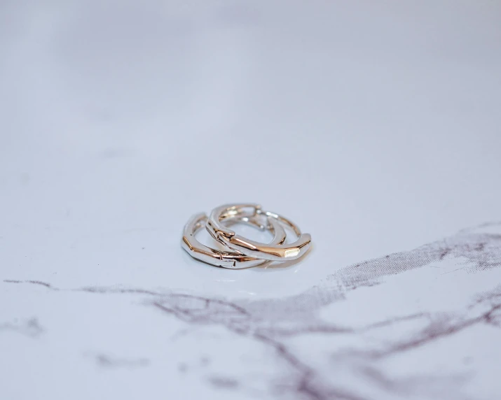 an empty white marble counter with three rings laying on it