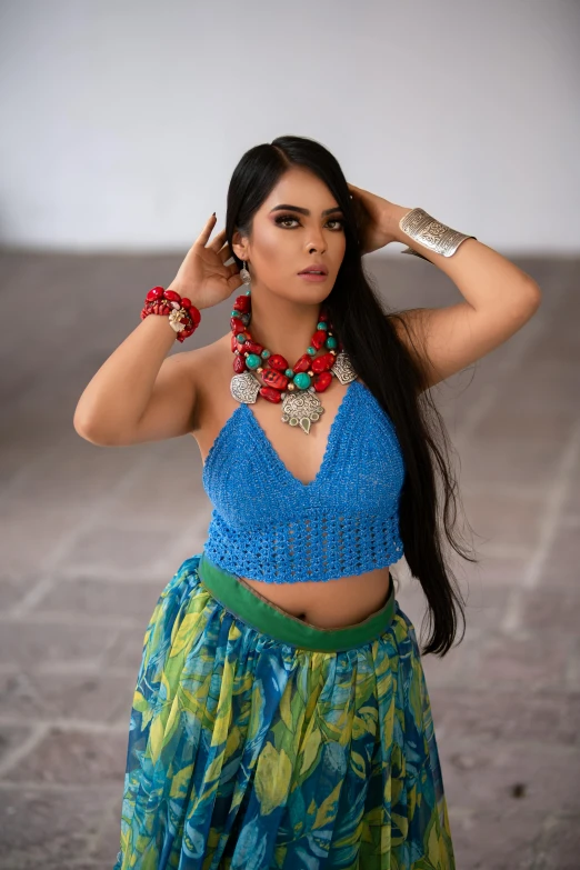a young woman wearing a blue top and floral skirt
