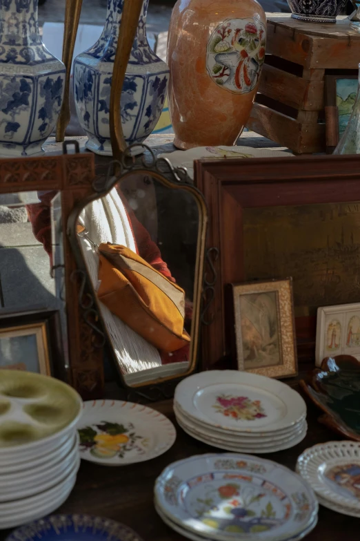 a table topped with lots of plates and vases