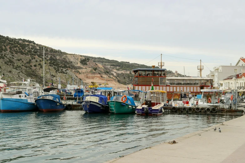 a row of boats docked in the water near buildings