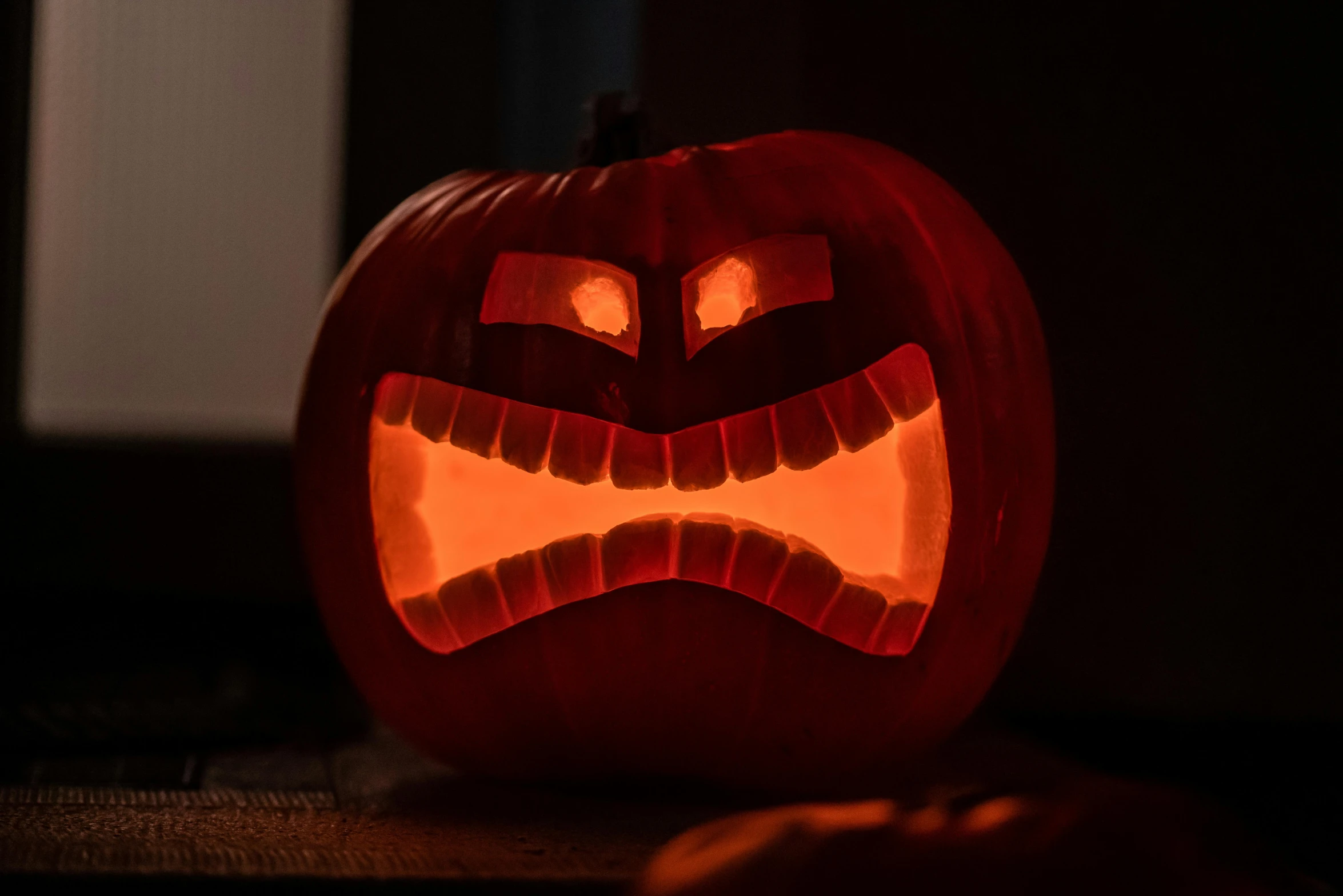 a jack o lantern carved to look like an angry pumpkin