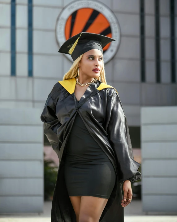 a woman wearing a black graduation gown and a gold tassel