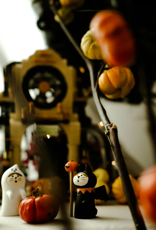 some colorful pumpkins with small figurines and plants in the background