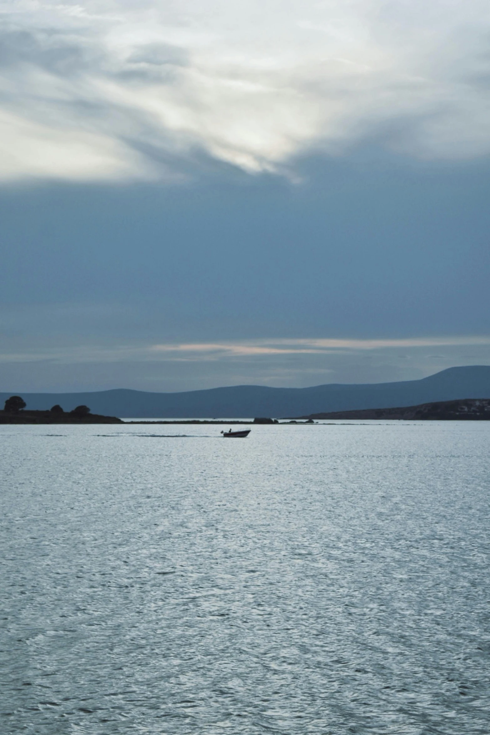 two boats in the ocean near a mountain range