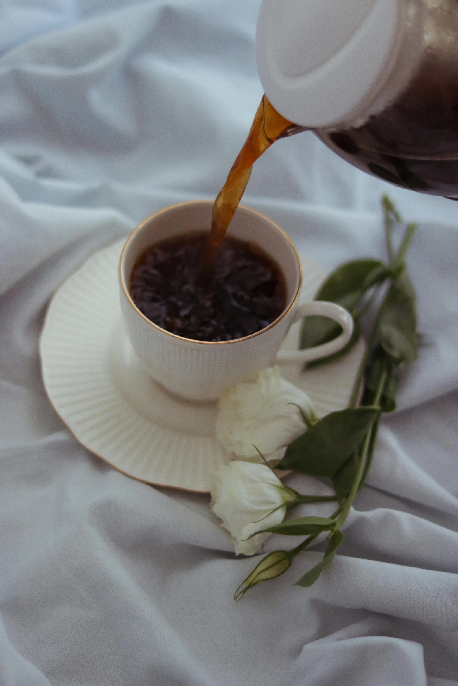 someone pours some tea into their cup