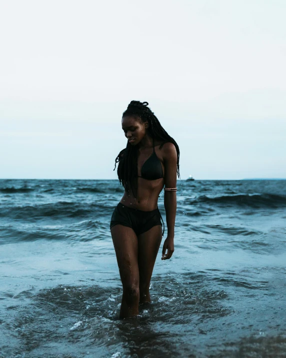 a woman in a bathing suit is standing in the water