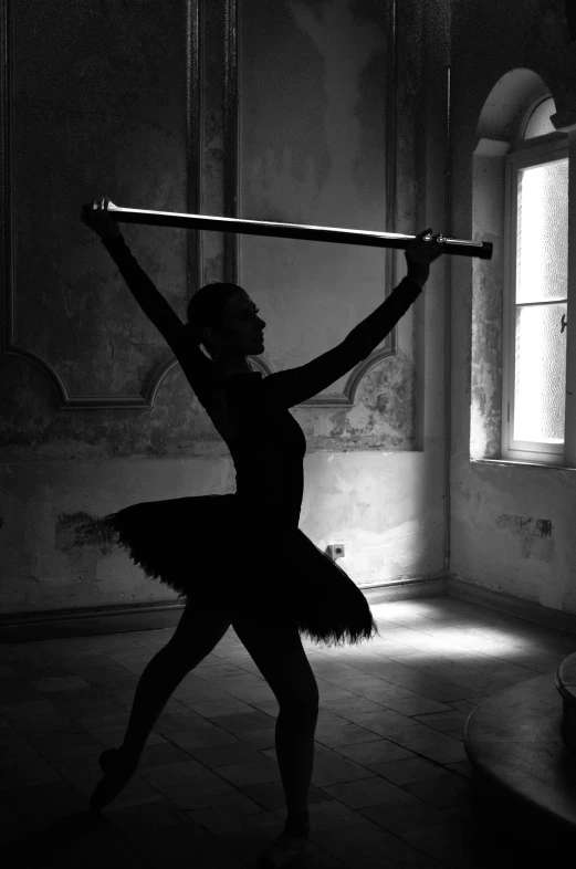 the young ballet woman has a huge wooden stick