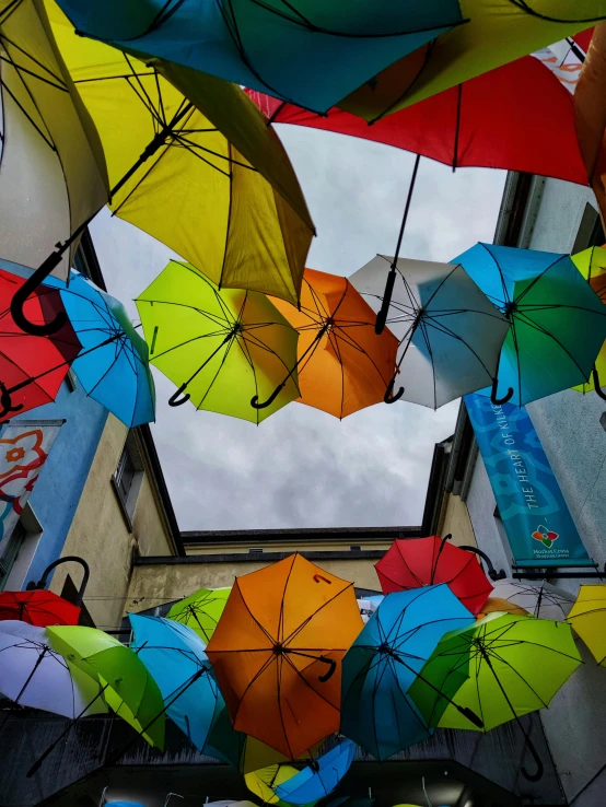 many different colored umbrellas are hanging in the air