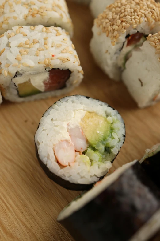 a group of sushi is on a wooden table