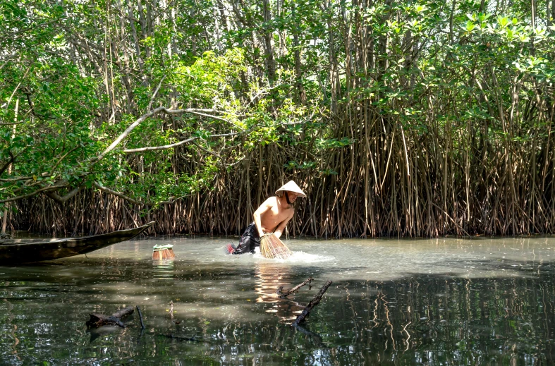 a man stands in water with a dog