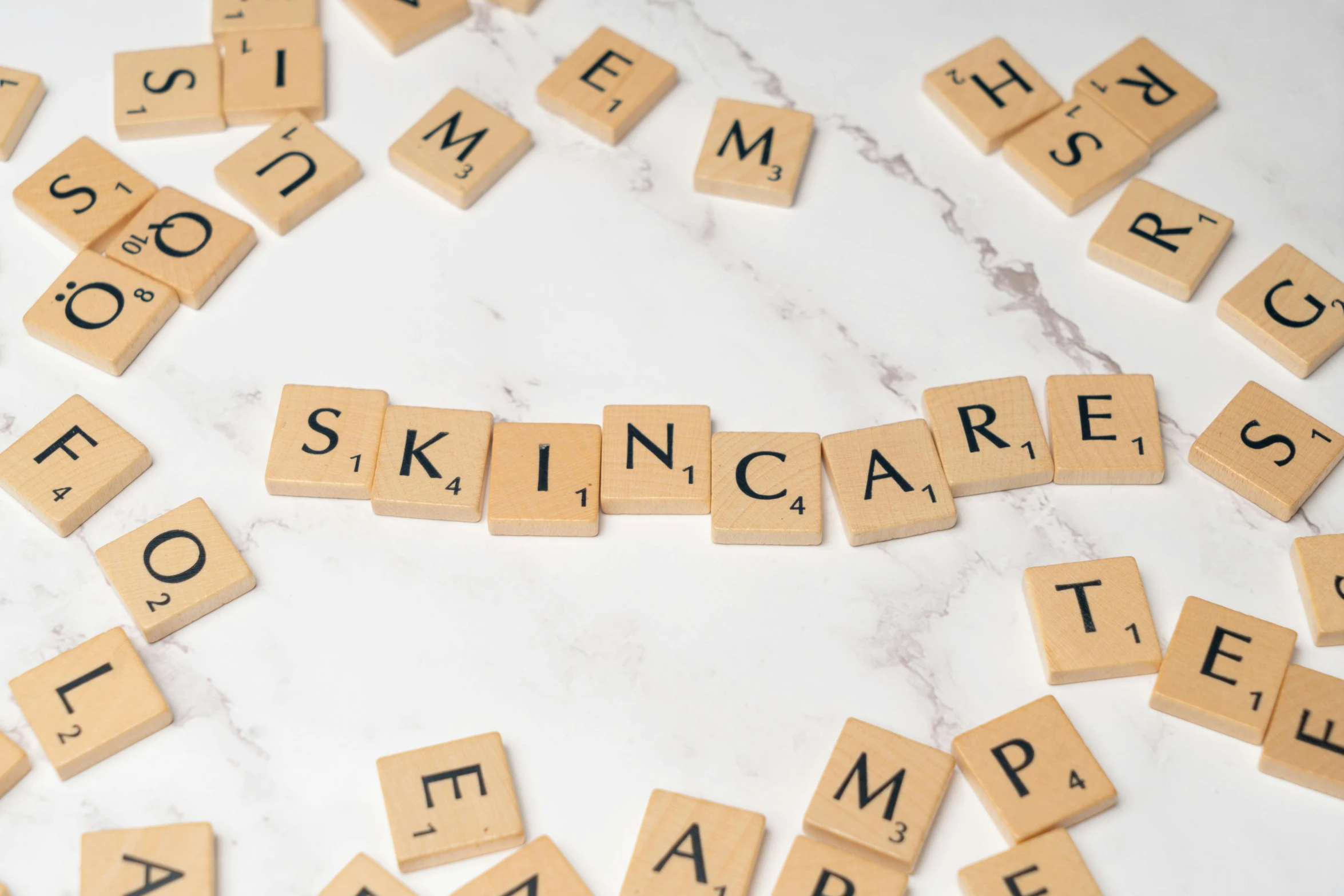 several scrabbled tiles spelling skin care and spelled by letters