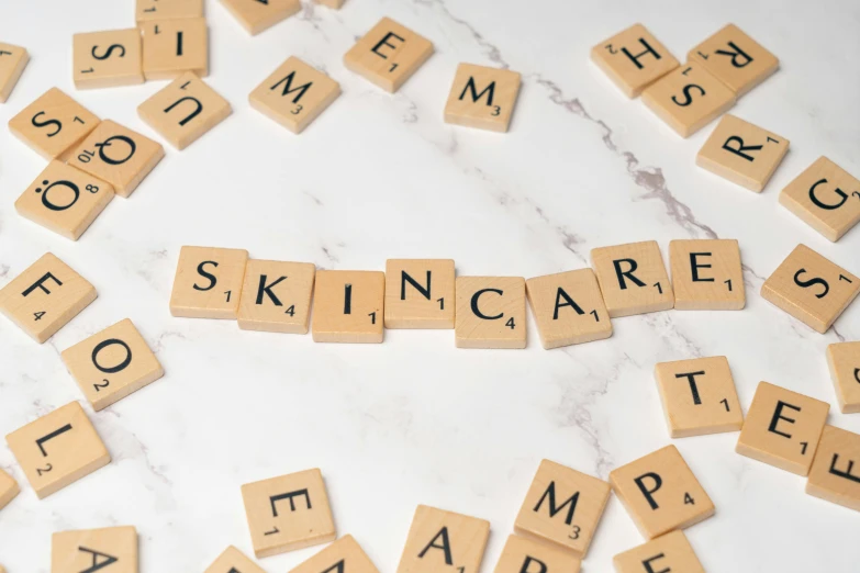 several scrabbled tiles spelling skin care and spelled by letters