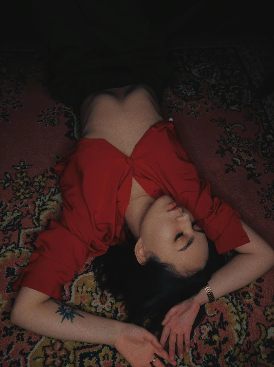 woman lying down on carpet in red dress