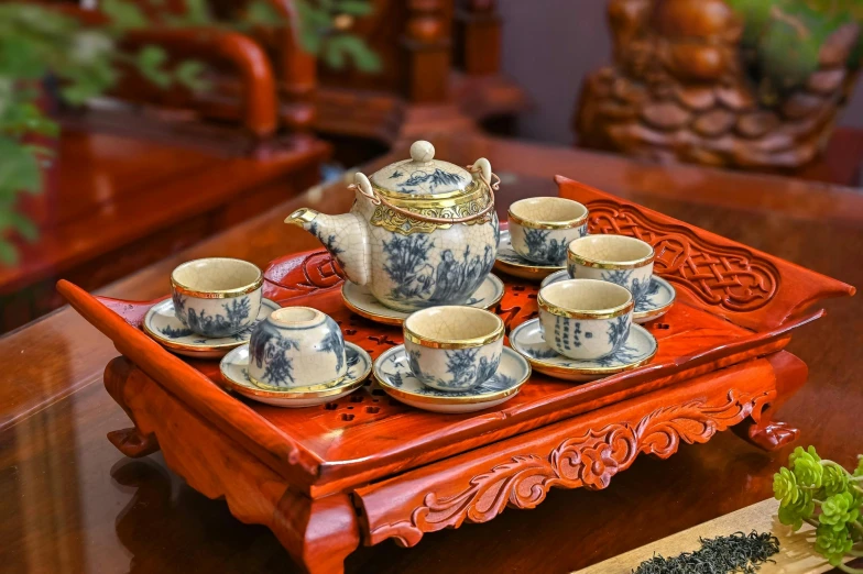 the tea set is sitting on the tray, near other tea cups and saucers