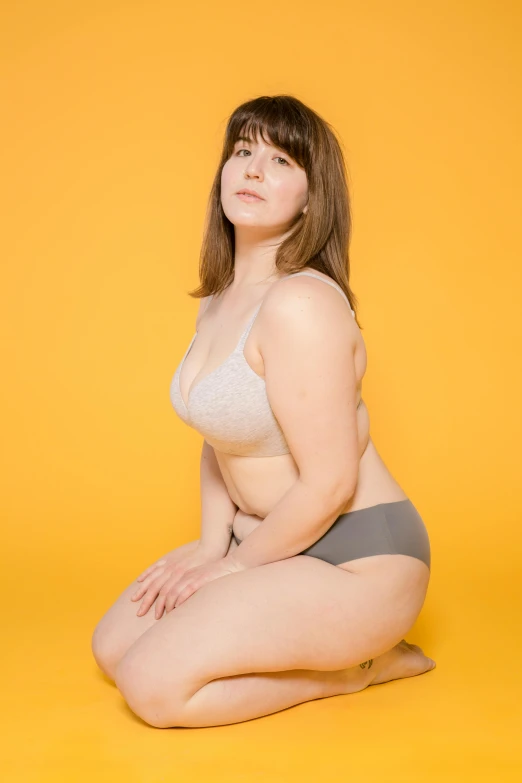 a woman is sitting on the floor in a bikini