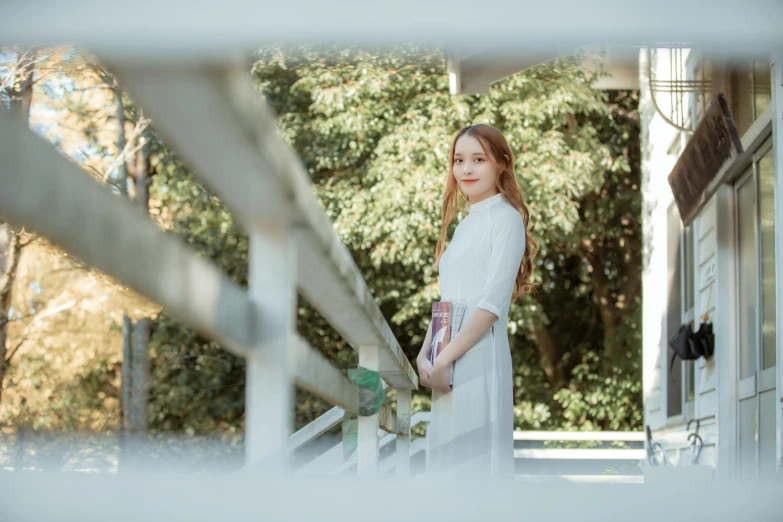 a woman stands on the porch in front of a house