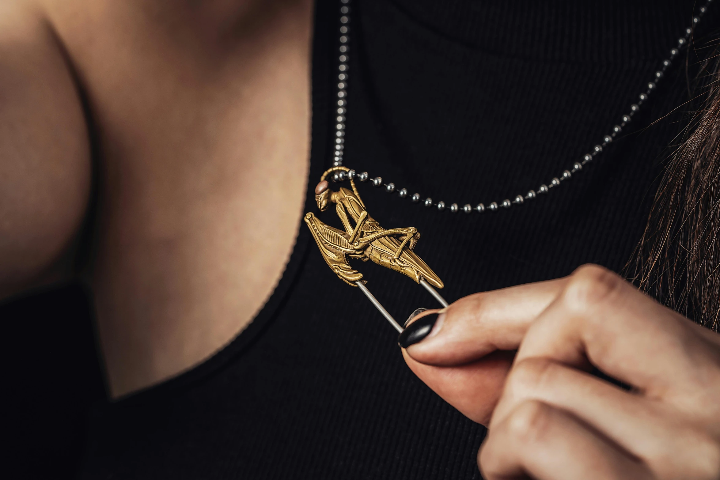 the woman is holding a pendant in her hands