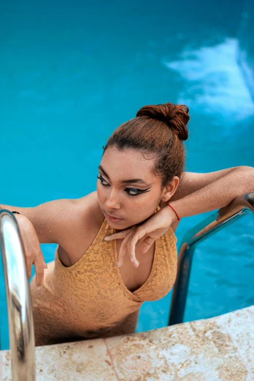 a woman with a ponytail leaning on a pool ledge