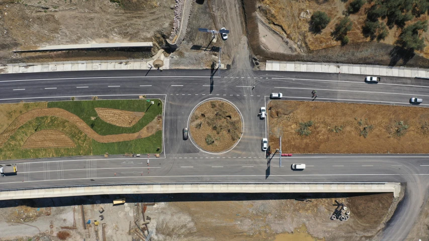 an overhead view of a highway intersection surrounded by trees