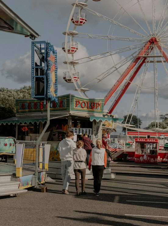 a group of people in white coats standing near a carnival